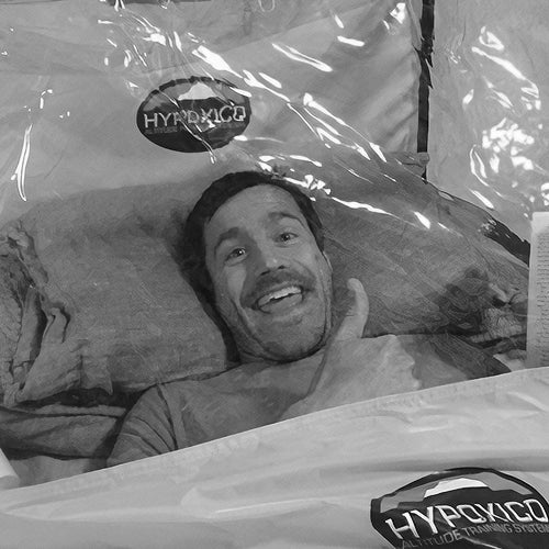 Man giving thumbs up inside altitude training tent