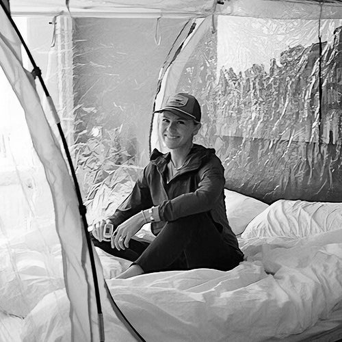 Woman sitting inside an altitude training tent on a bed