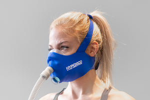 Training mask with dual exhalation valves and adjustable head straps, shown on plain background.