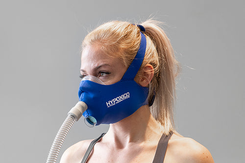 A woman with blonde hair in a ponytail wears a blue