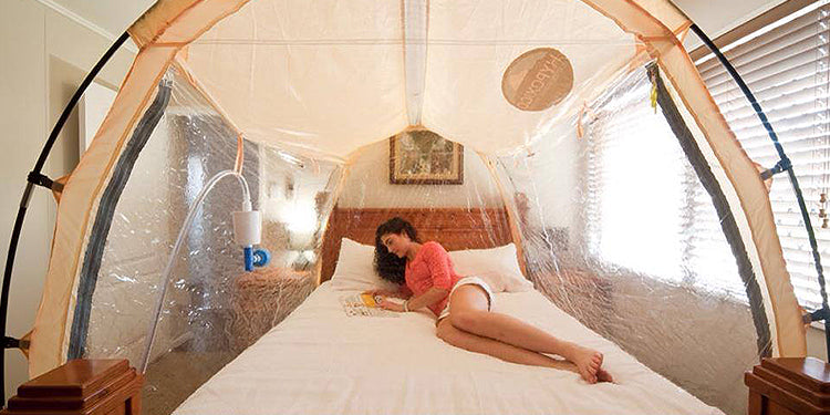 Woman laying in bed inside an altitude tent